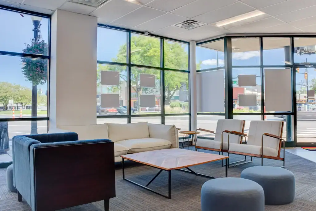 Waiting area with sofas and armchairs by large windows