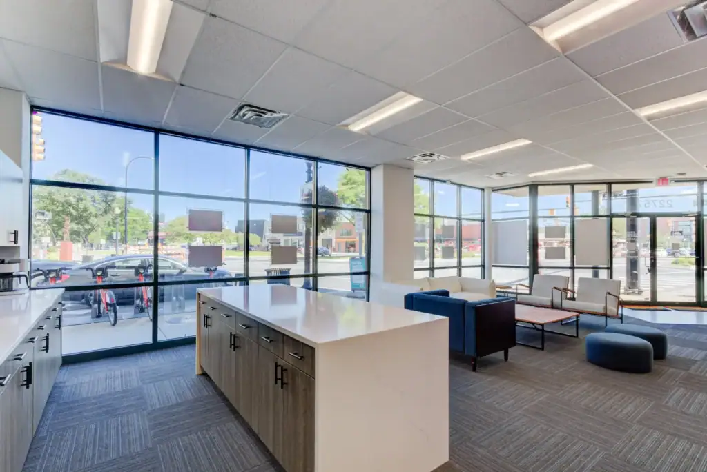 Interior with large windows, a white countertop, and blue and white seating