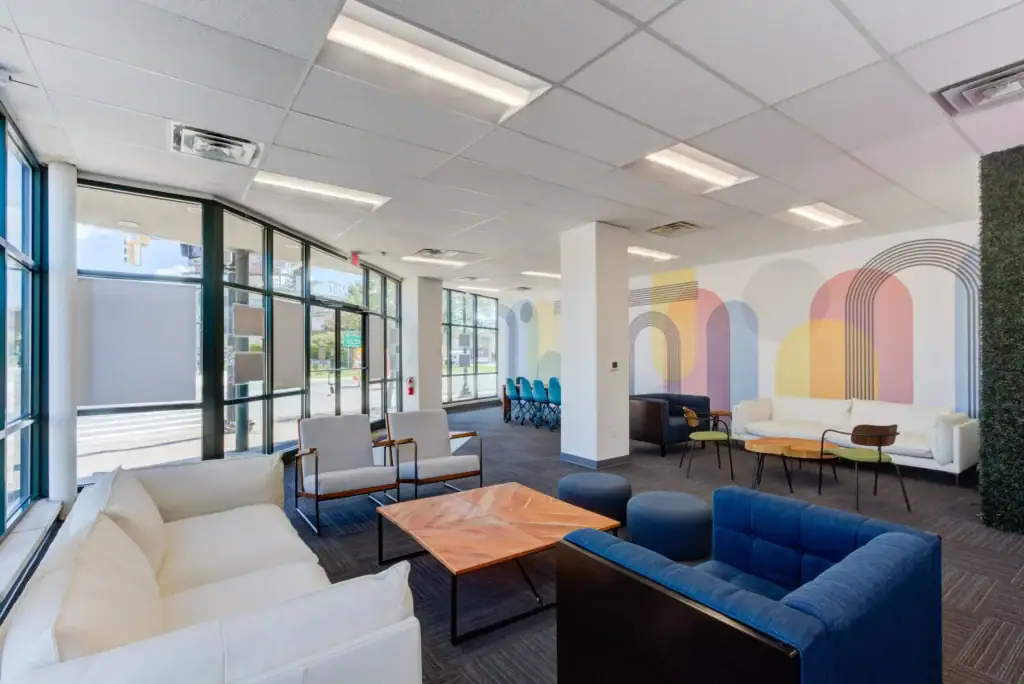 Lounge with comfortable seating, geometric wall art, and large windows