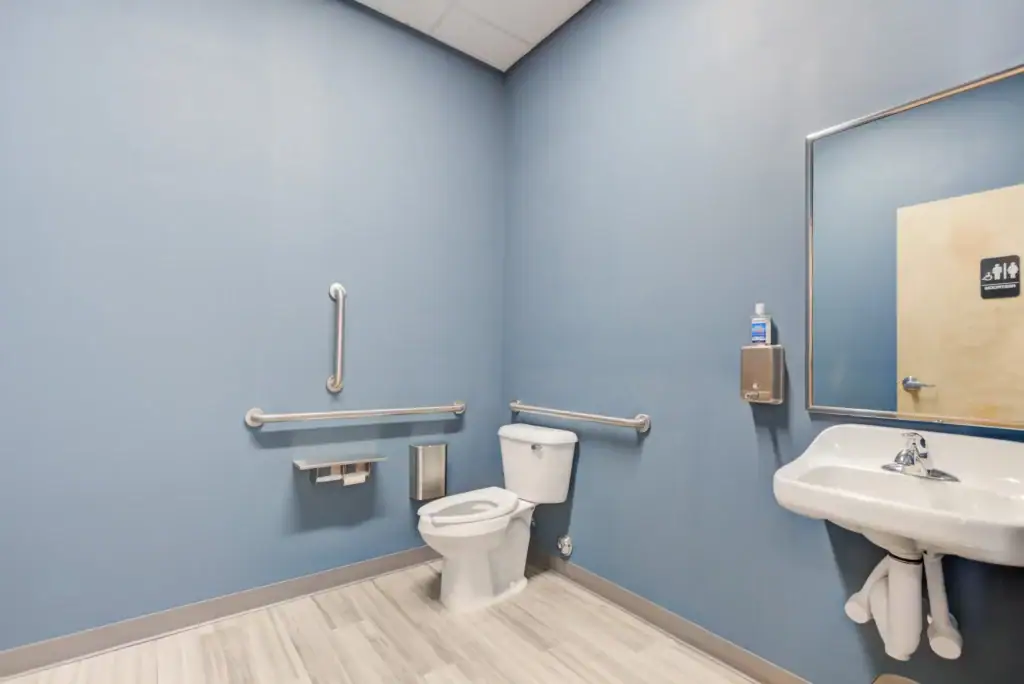 Accessible restroom with grab bars, sink, and mirror
