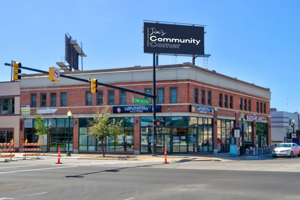 Street corner with signs for Jim's Community Corner and Jim Shaffer and Associates Realtors on Nine Mile Rd