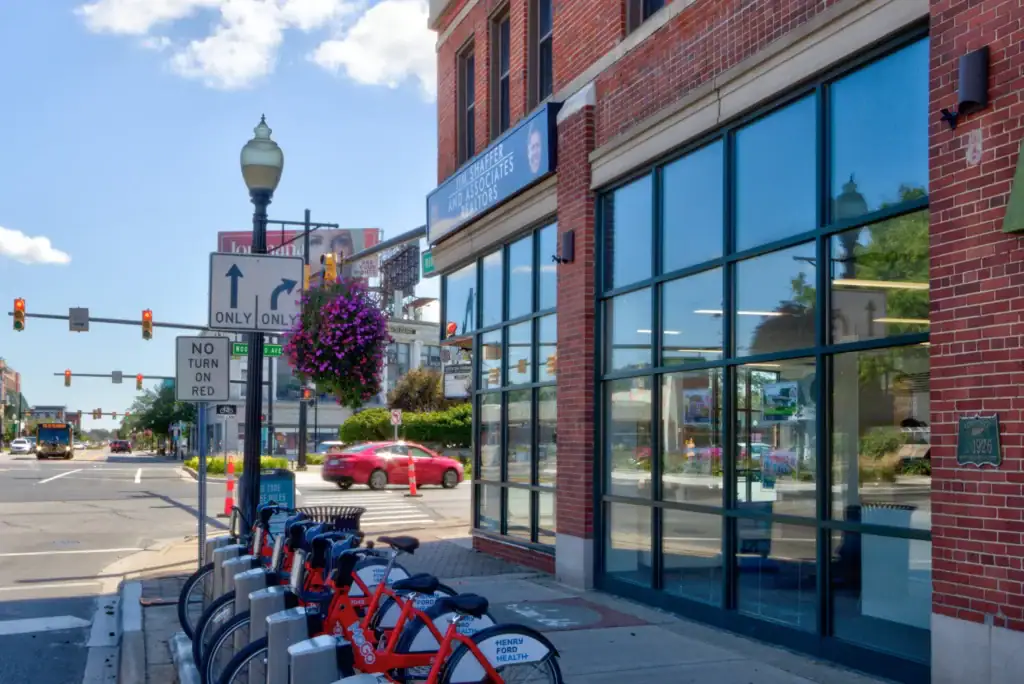 Woodward Avenue streetscape with the Community Corner building, bike station, and flower baskets